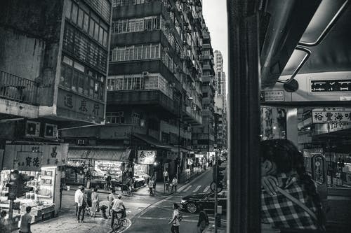 高层建筑附近行走的人的灰度摄影 · 免费素材图片