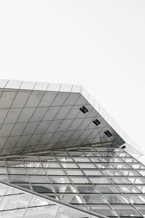 低角度拍摄的黑色和白色的现代玻璃建筑 · 免费素材图片
