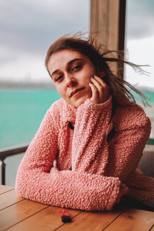 靠在木桌上的女人的照片 · 免费素材图片