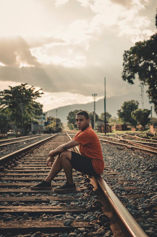 白天坐在铁路上的人 · 免费素材图片
