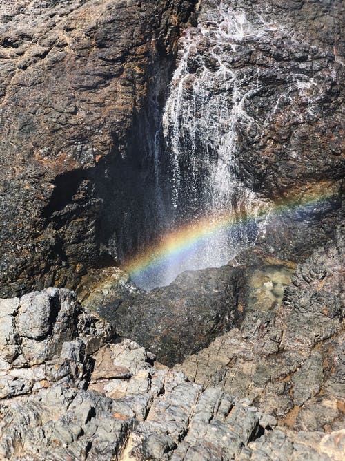 彩虹反射在水流过岩石 · 免费素材图片