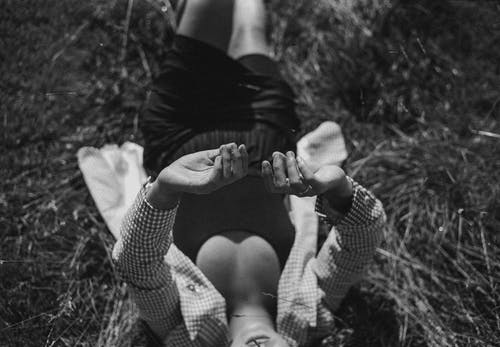 躺在草地上的人的灰度摄影 · 免费素材图片