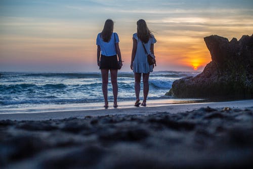 两个女人站在水的附近 · 免费素材图片