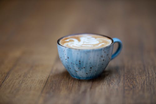 棕色木制表面上的蓝色陶瓷咖啡杯 · 免费素材图片