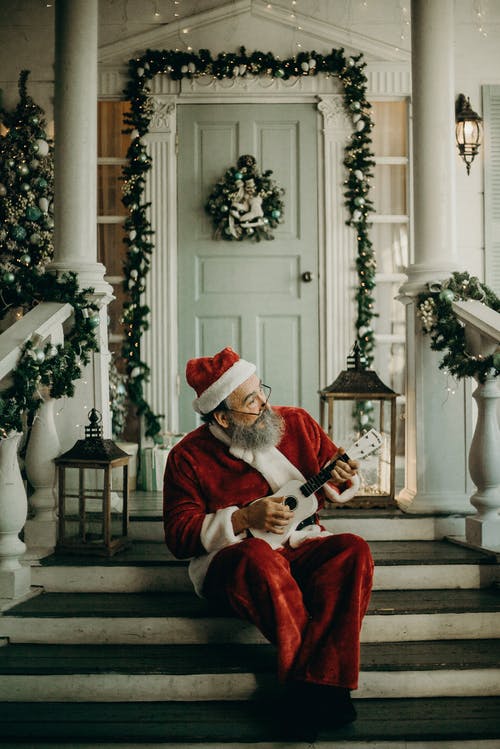 圣诞老人服装坐在门边的人 · 免费素材图片