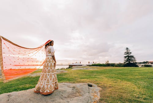 女人站在岩石上穿纱丽 · 免费素材图片