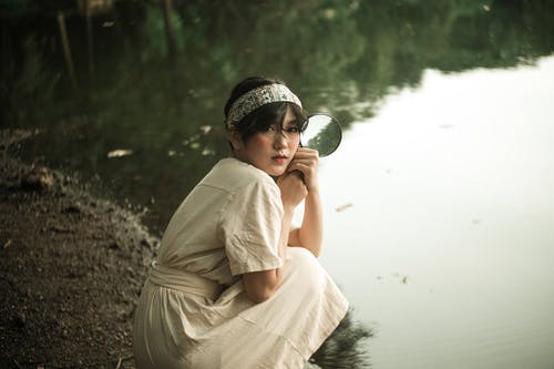 坐在水边附近的女人 · 免费素材图片