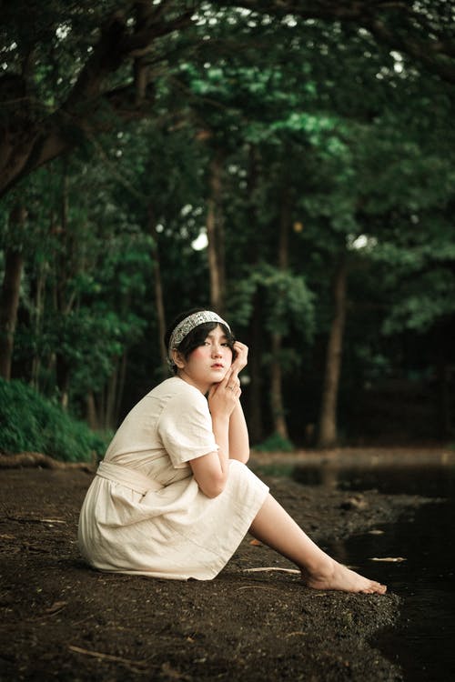 坐在湖边的白色连衣裙的女人 · 免费素材图片