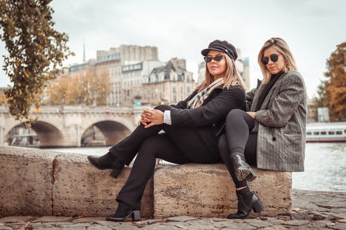 妇女坐在棕色的岩石上 · 免费素材图片