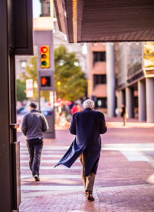 人在人行道上行走时穿风衣 · 免费素材图片