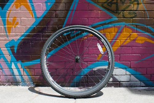 黑色自行车车轮倚在墙上 · 免费素材图片