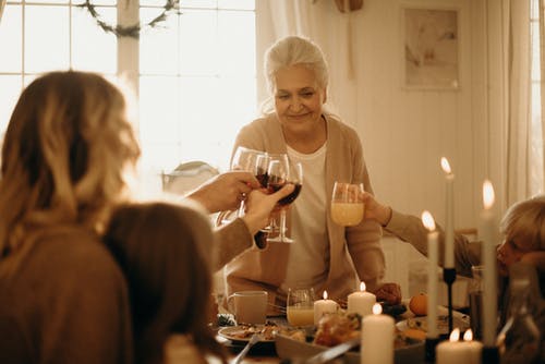 灰色羊毛衫站在桌子旁做干杯的女人 · 免费素材图片
