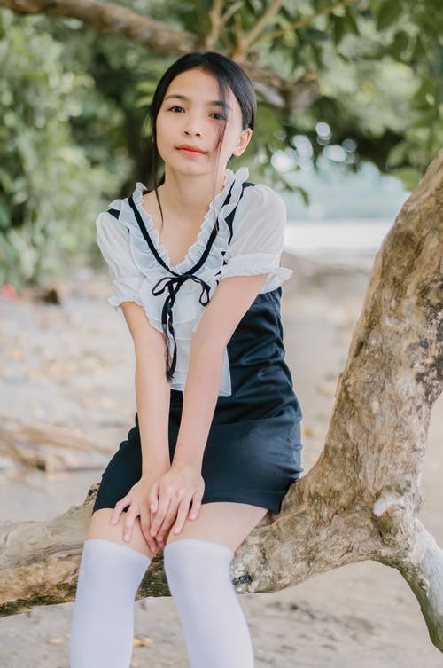 女人坐在树干上 · 免费素材图片