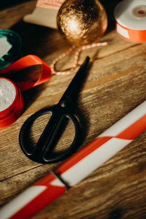 棕色木质表面上的黑柄剪刀 · 免费素材图片