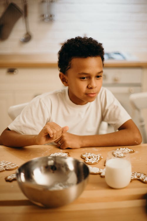 男孩在桌子旁边的选择性聚焦摄影饼干 · 免费素材图片