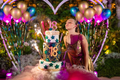 在庆祝期间在蛋糕上吹蜡烛的生日女人 · 免费素材图片