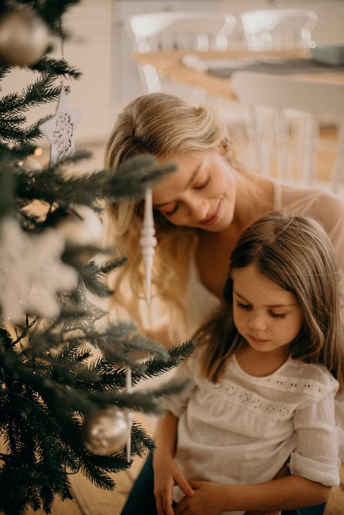 女人和女孩站在圣诞树旁边 · 免费素材图片