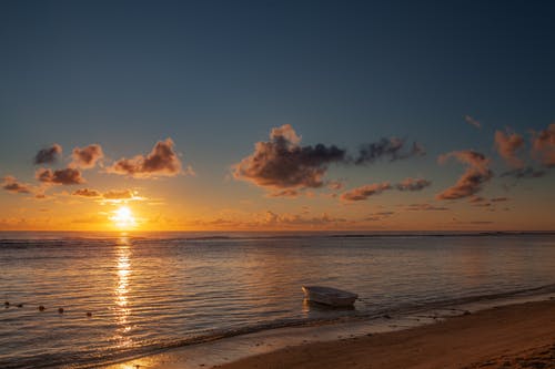 白船在日出时橙色和蓝色的天空下的海上 · 免费素材图片
