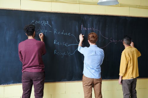 用粉笔在黑板上扭动的男人 · 免费素材图片