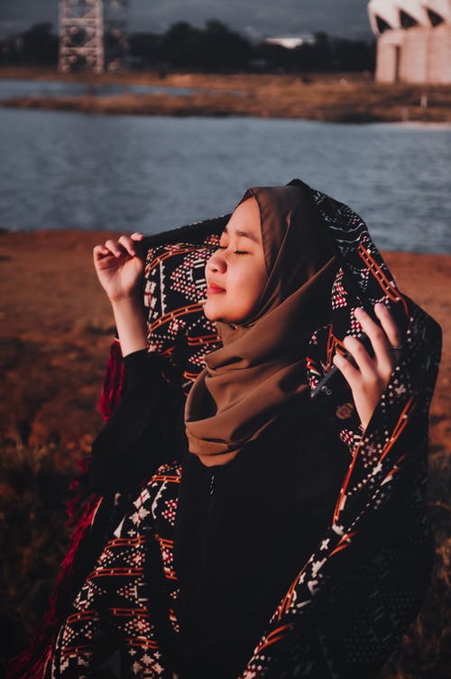 女人抱着她的围巾 · 免费素材图片