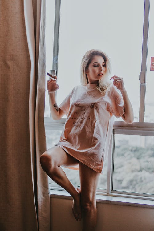 靠在窗户上的女人的照片 · 免费素材图片