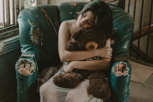 女人抱着棕熊毛绒玩具 · 免费素材图片