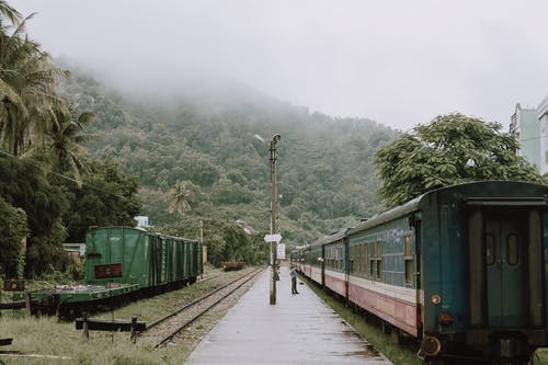 站在一辆古老的火车在靠近山顶的t虫草的火车停靠站的人 · 免费素材图片