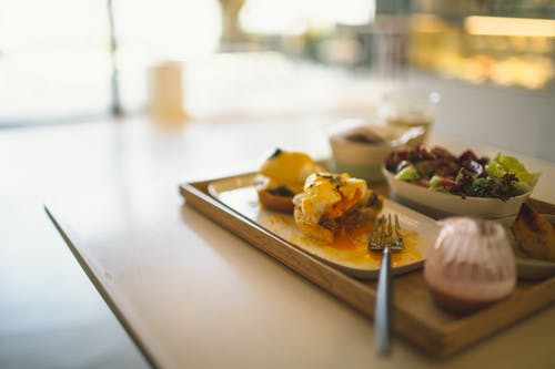 棕色木制托盘上的蔬菜沙拉和早餐滑块 · 免费素材图片