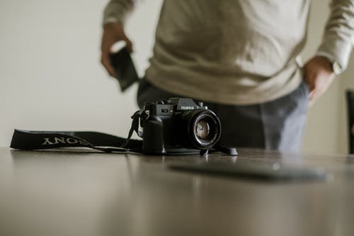 近人桌上的相机 · 免费素材图片