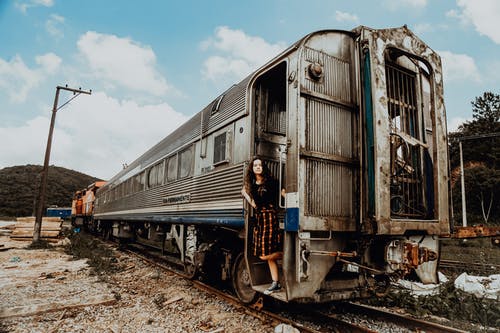 黑顶站在灰色和白色的火车门上的女人 · 免费素材图片