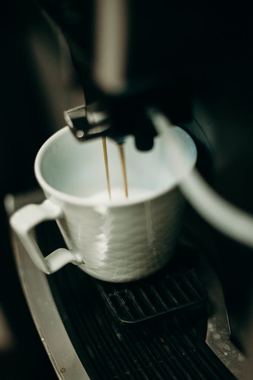 白色陶瓷杯咖啡从咖啡机倒 · 免费素材图片