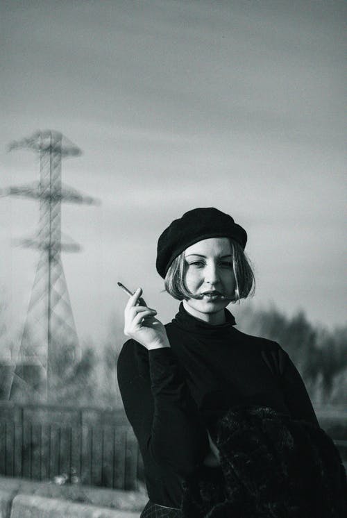 一个女人抱着雪茄的灰度照片 · 免费素材图片