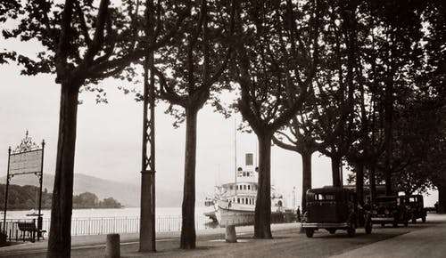 汽车在河边一条街上的老黑白照片，船停靠在码头上 · 免费素材图片