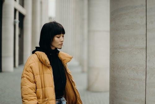 芥末黄泡泡全拉链外套摆姿势的女人的照片 · 免费素材图片