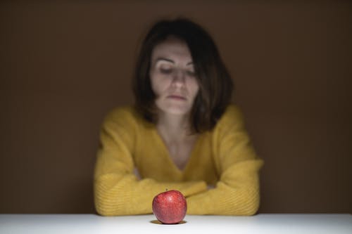 坐在红苹果果实附近的女人 · 免费素材图片