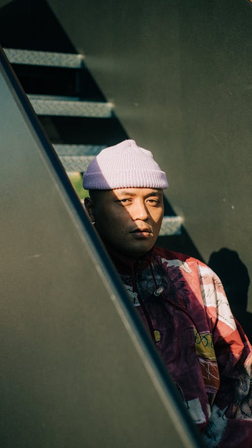 男子站在金属楼梯附近 · 免费素材图片