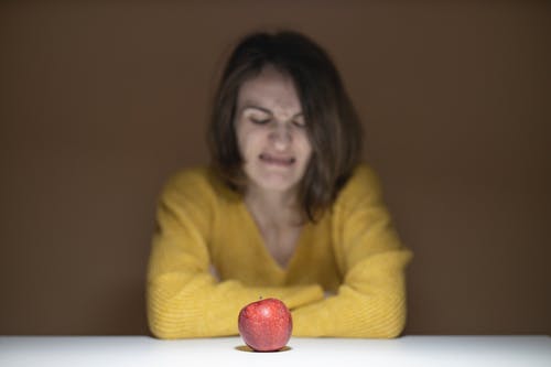 女人厌恶地看着苹果 · 免费素材图片
