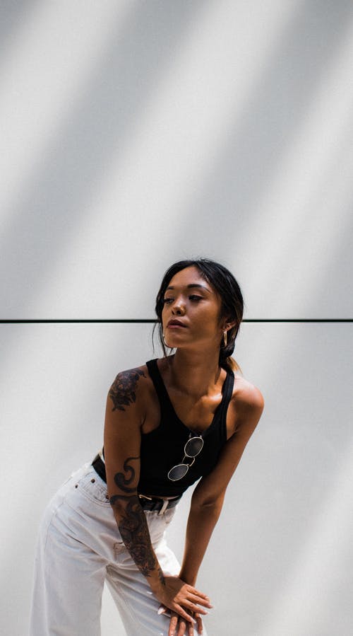 女人穿着黑色背心和白色的裤子摆姿势 · 免费素材图片