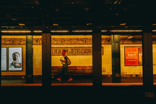 身穿黑色上衣和红色头巾在地铁上行走的人 · 免费素材图片