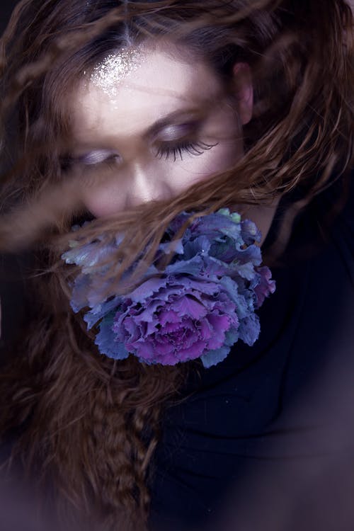 一个女人的概念摄影，有特别长的鞭子，一朵蓝色的花遮住她的嘴 · 免费素材图片