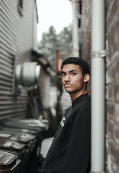男子倚在墙上 · 免费素材图片