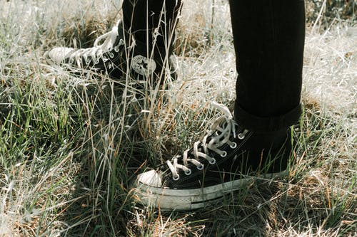 站立在草的运动鞋的无法认出的人 · 免费素材图片