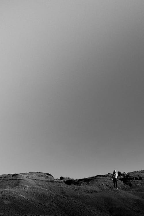 站在沙漠上的人的单色照片 · 免费素材图片