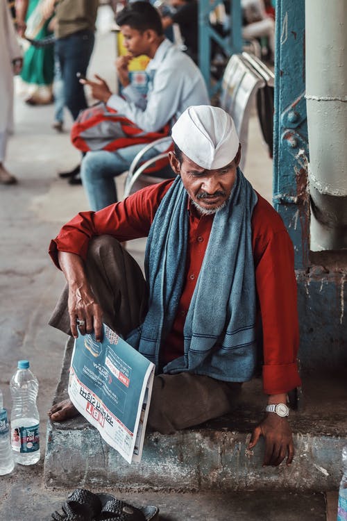 男子坐在人行道上的照片 · 免费素材图片