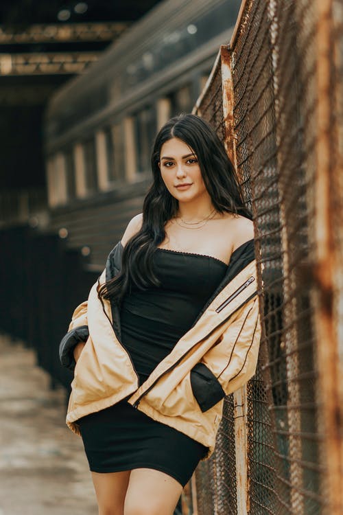 女人靠在栅栏上的照片 · 免费素材图片