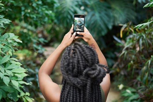 女人抱着黑色的智能手机 · 免费素材图片