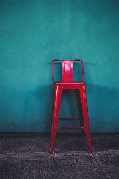 蓝绿色墙旁的红色椅子 · 免费素材图片