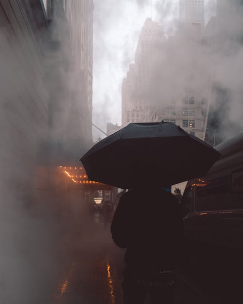 使用黑色雨伞穿黑夹克的人 · 免费素材图片