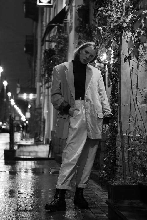 女人站在混凝土建筑物附近的灰度摄影 · 免费素材图片