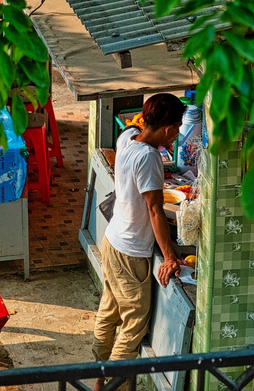 一个人站在一个小木档前的高角度油烟 · 免费素材图片